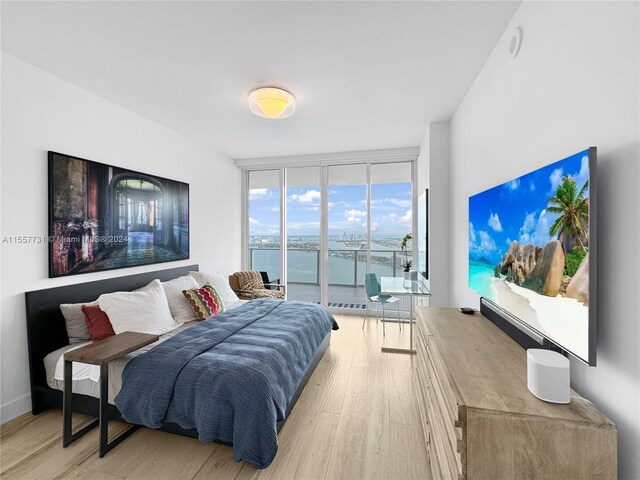 bedroom featuring light wood-type flooring and expansive windows