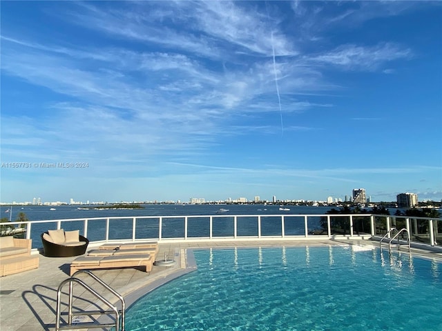 view of swimming pool featuring a water view