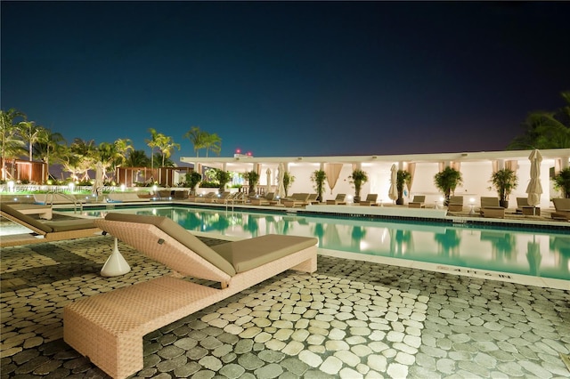 pool at twilight featuring a patio