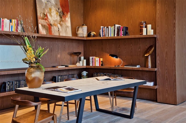 home office with hardwood / wood-style floors and wooden walls