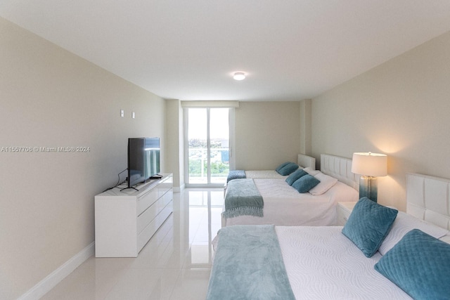 bedroom with a wall of windows and light tile floors