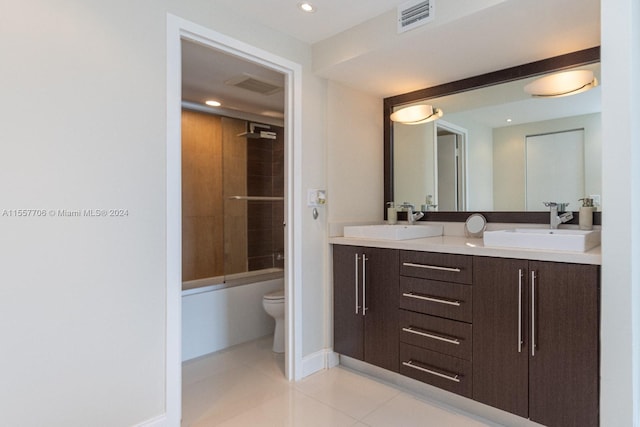 full bathroom with toilet, double vanity, tile floors, and tiled shower / bath