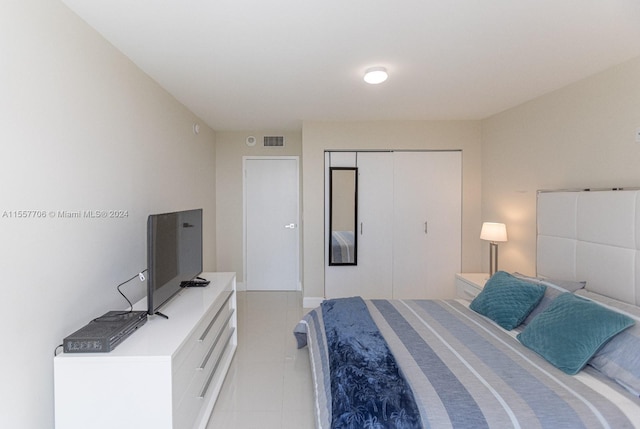 bedroom with a closet and light tile floors