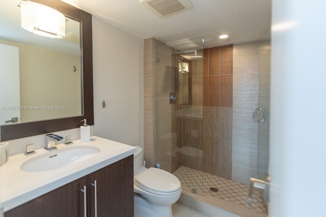 bathroom with toilet, walk in shower, and vanity