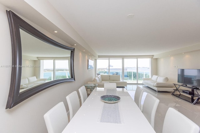 dining area with a water view and a wall of windows