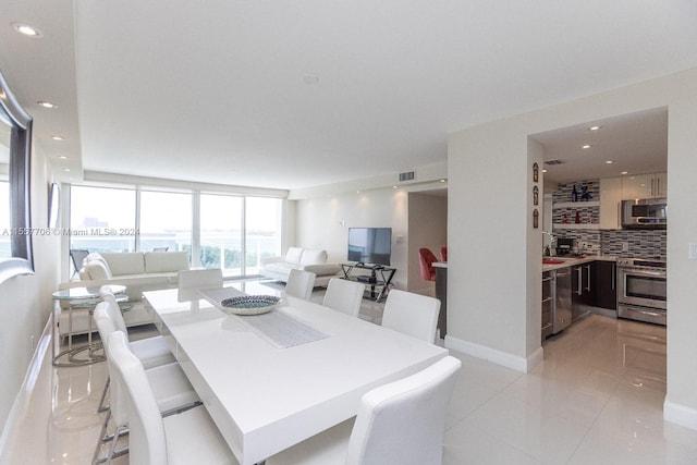 dining room with a wall of windows and light tile floors