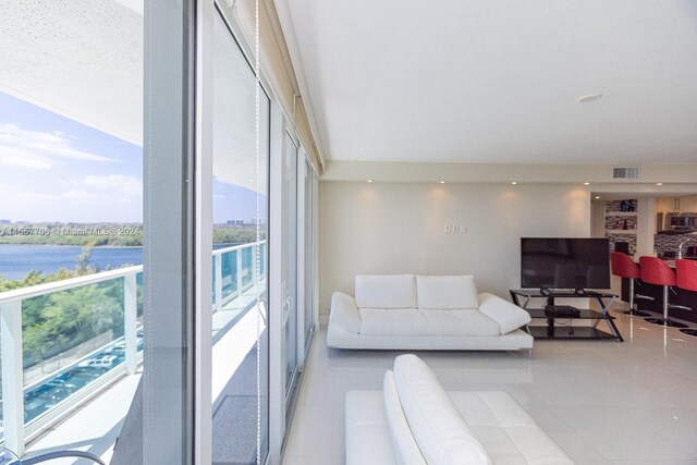 living room with a water view and light tile floors