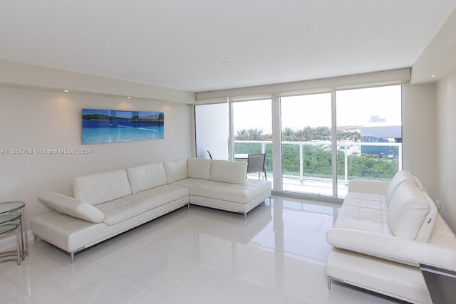 living room featuring light tile flooring and a wall of windows