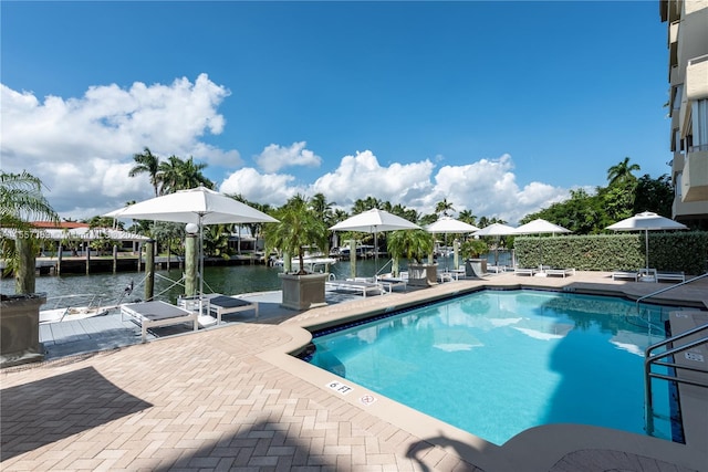 view of pool with a boat dock and a patio area