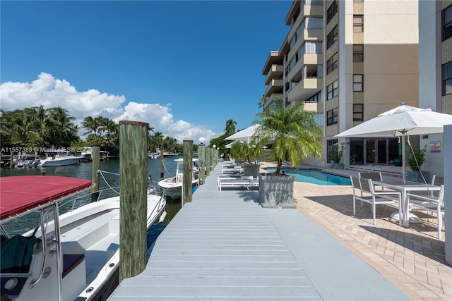 dock area with a water view and a community pool