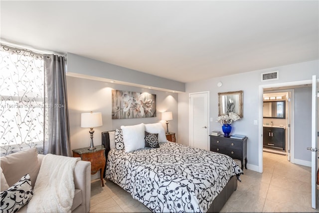 tiled bedroom with a closet, connected bathroom, and multiple windows