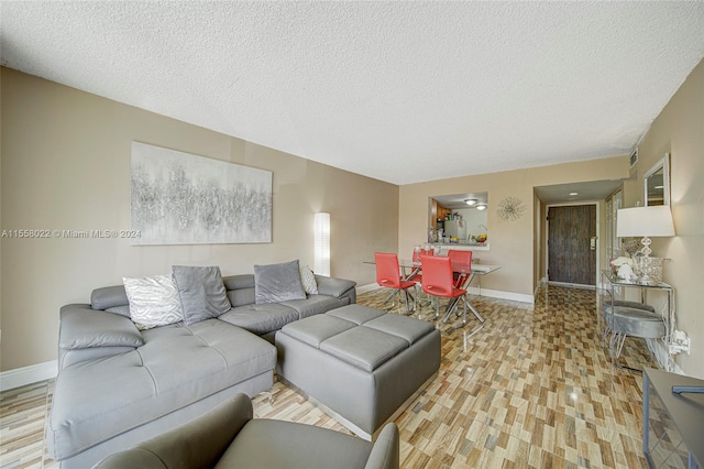 living room with a textured ceiling and light hardwood / wood-style floors