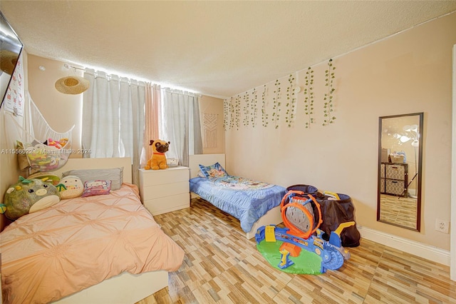 bedroom with light hardwood / wood-style flooring and a textured ceiling