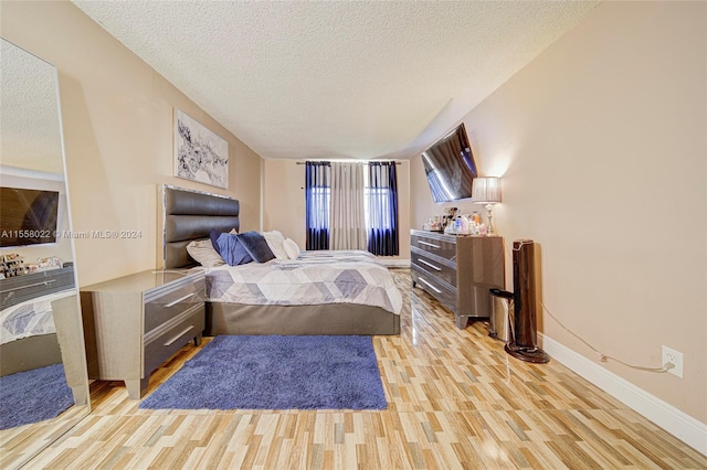 bedroom featuring a textured ceiling and light wood-type flooring