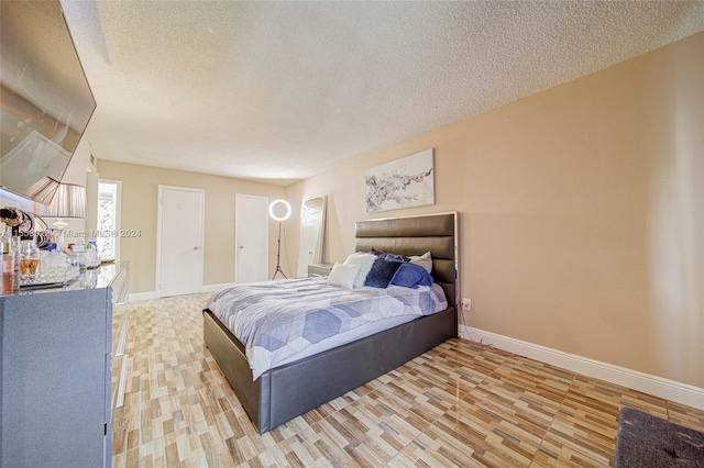 bedroom with light hardwood / wood-style flooring and a textured ceiling