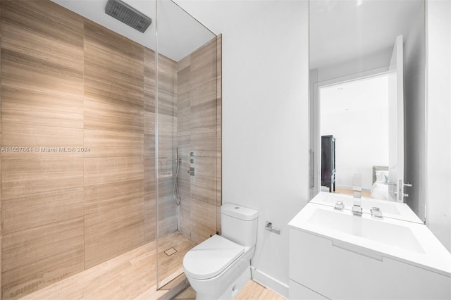 bathroom featuring a shower with shower door, vanity, and toilet