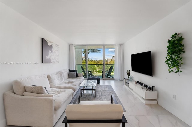 living room with a wall of windows and light tile floors