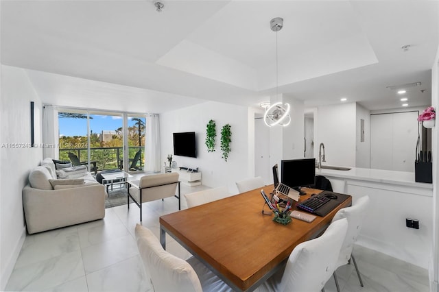 tiled dining area with a notable chandelier, a tray ceiling, and sink