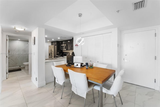 tiled dining room featuring a tray ceiling