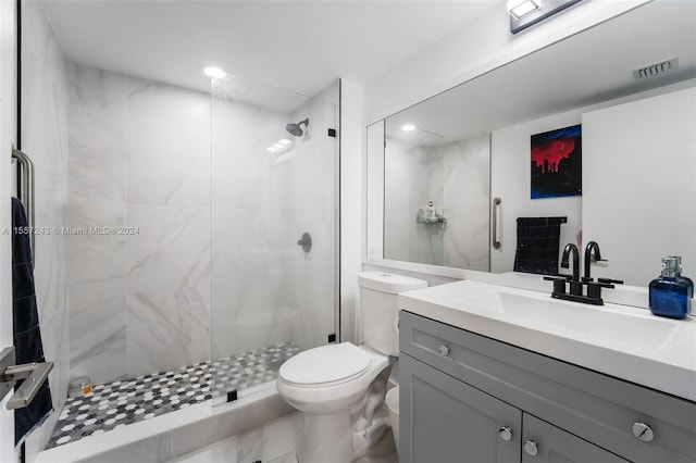 bathroom with vanity, tile floors, toilet, and tiled shower