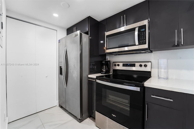 kitchen featuring light tile flooring and stainless steel appliances