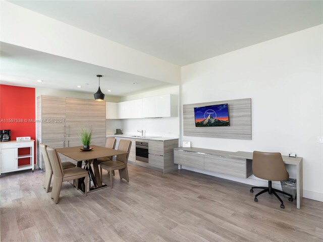 dining area with sink and light hardwood / wood-style floors