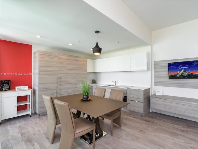 dining space with sink and light hardwood / wood-style flooring