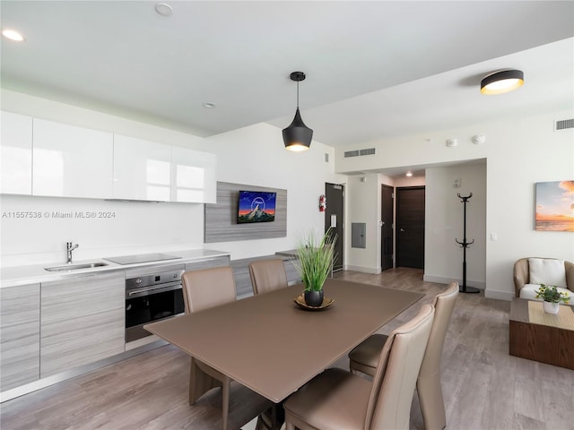 dining area with sink and light hardwood / wood-style floors