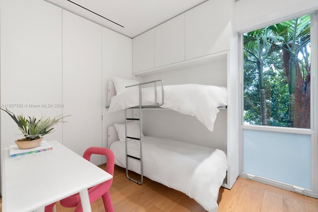 bedroom with multiple windows and light wood-type flooring