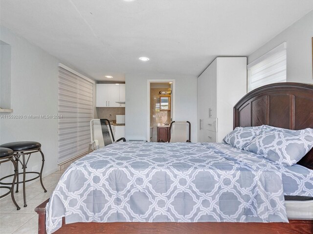 bedroom with light tile floors and ensuite bath