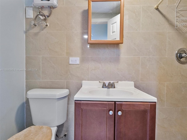 bathroom featuring tile walls, toilet, and vanity