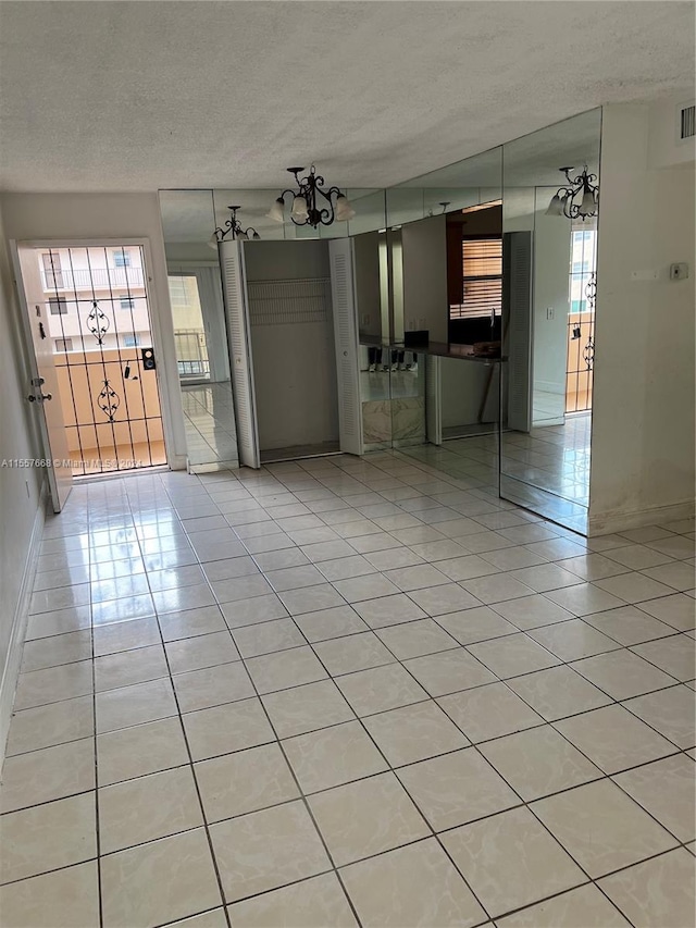 tiled empty room with a textured ceiling