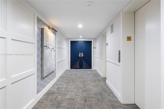 corridor with carpet flooring and elevator