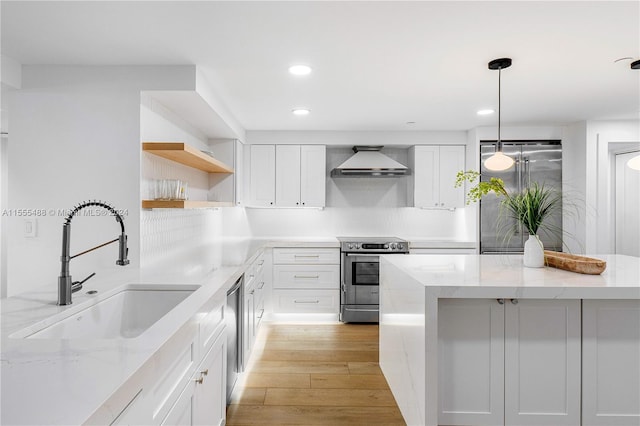 kitchen with sink, white cabinets, light hardwood / wood-style flooring, stainless steel appliances, and light stone countertops