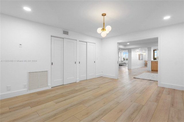 interior space featuring a notable chandelier and light wood-type flooring