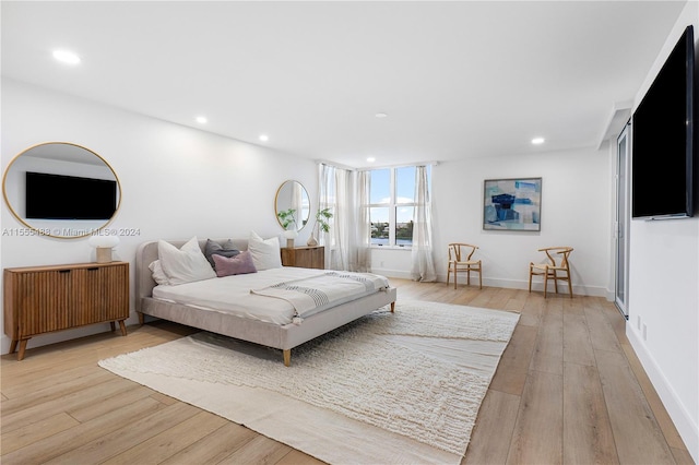 bedroom with light wood-type flooring and radiator heating unit