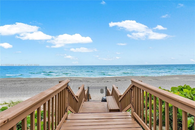 view of home's community featuring a water view and a beach view