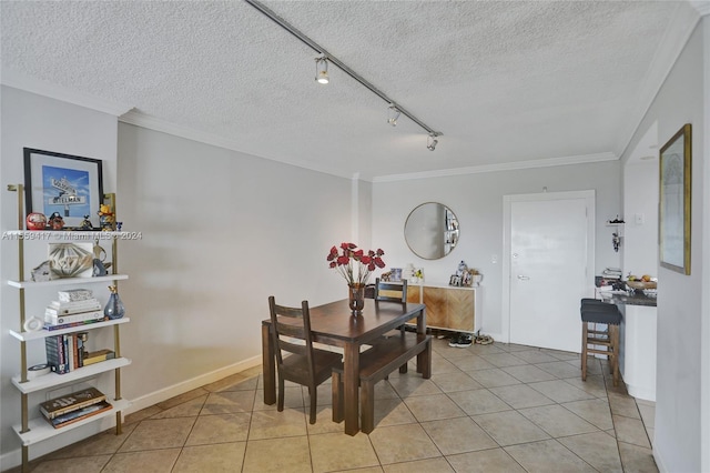 tiled dining area with ornamental molding and a textured ceiling