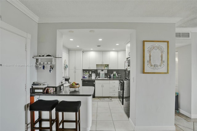 kitchen featuring a breakfast bar, white cabinetry, black dishwasher, light tile patterned floors, and kitchen peninsula