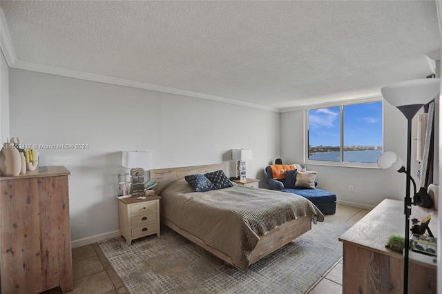 tiled bedroom featuring ornamental molding, a water view, and a textured ceiling