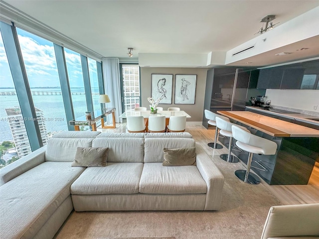 living room featuring hardwood / wood-style flooring, expansive windows, and a water view