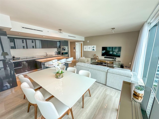 dining room with sink and light wood-type flooring