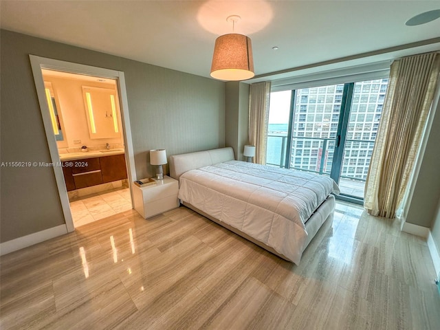 bedroom featuring connected bathroom, light tile floors, and access to outside