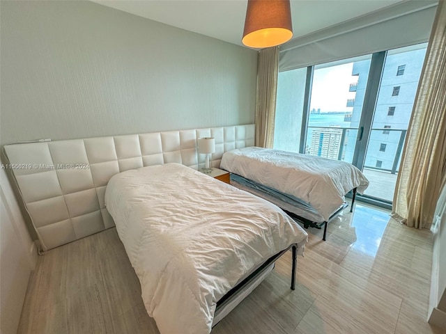 bedroom featuring wood-type flooring and access to exterior