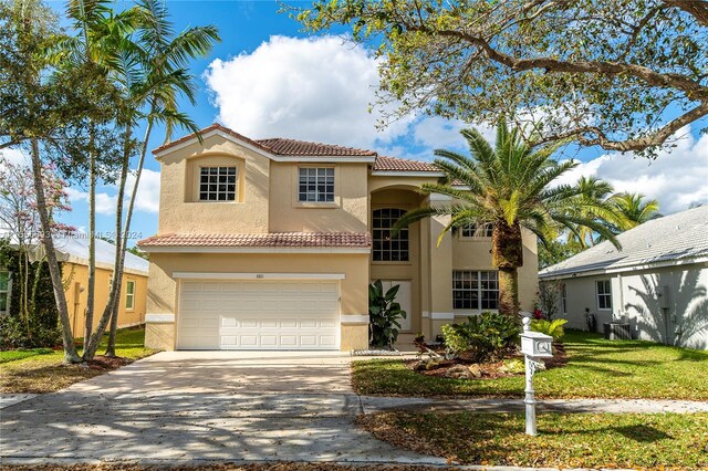 mediterranean / spanish house featuring a front yard and a garage