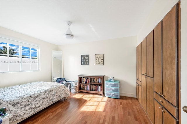 bedroom with light hardwood / wood-style floors and ceiling fan