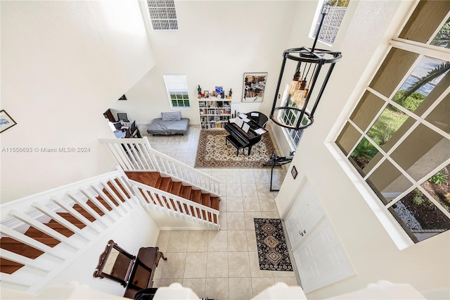 tiled living room featuring a high ceiling and a chandelier