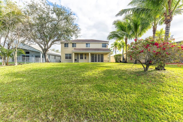 rear view of property featuring a lawn