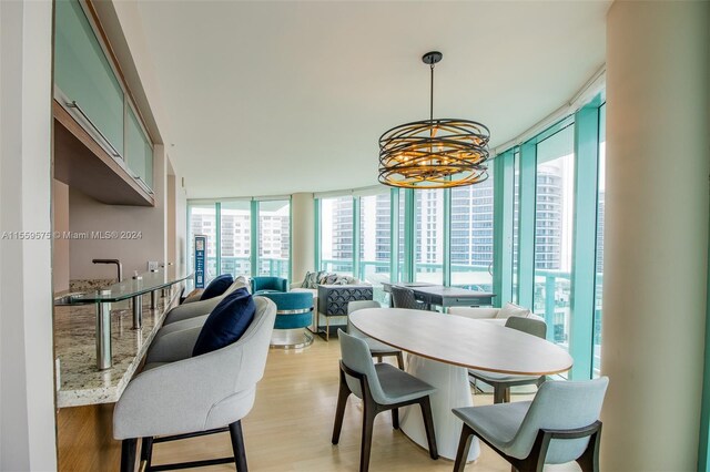 dining area featuring light hardwood / wood-style floors and an inviting chandelier