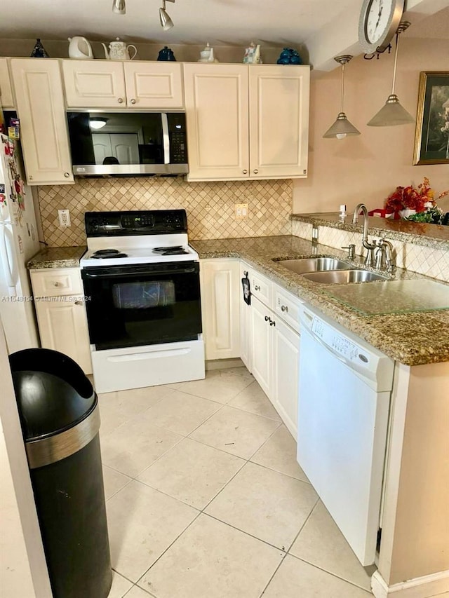 kitchen featuring kitchen peninsula, tasteful backsplash, white appliances, hanging light fixtures, and sink